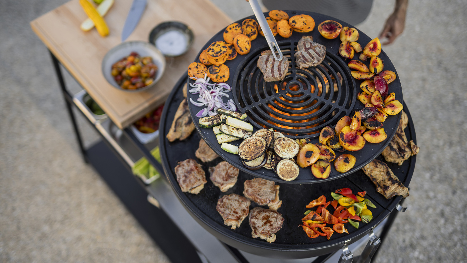 Szene, in der eine Person eine Vielzahl von Speisen kocht, wobei die 00617 Bowl 70 Warming Ring durch ihre praktische Eleganz hervorsticht.