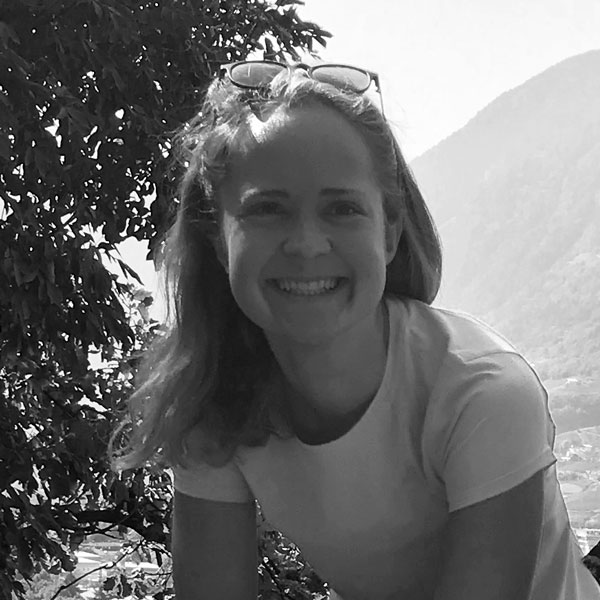 Eine Frau sitzt auf einer Bank in den Bergen.