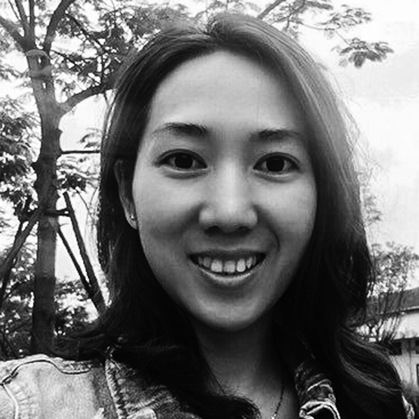 Eine Frau steht vor einem Baum.