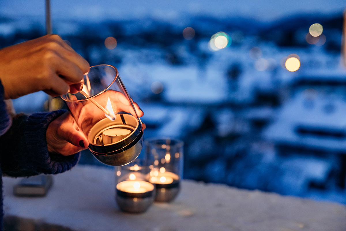 GRAVITY CANDLE Lantaarn zilver Een afbeelding van een persoon die een theelichtje in hun hand houdt, met de Gravity Candle in beeld.