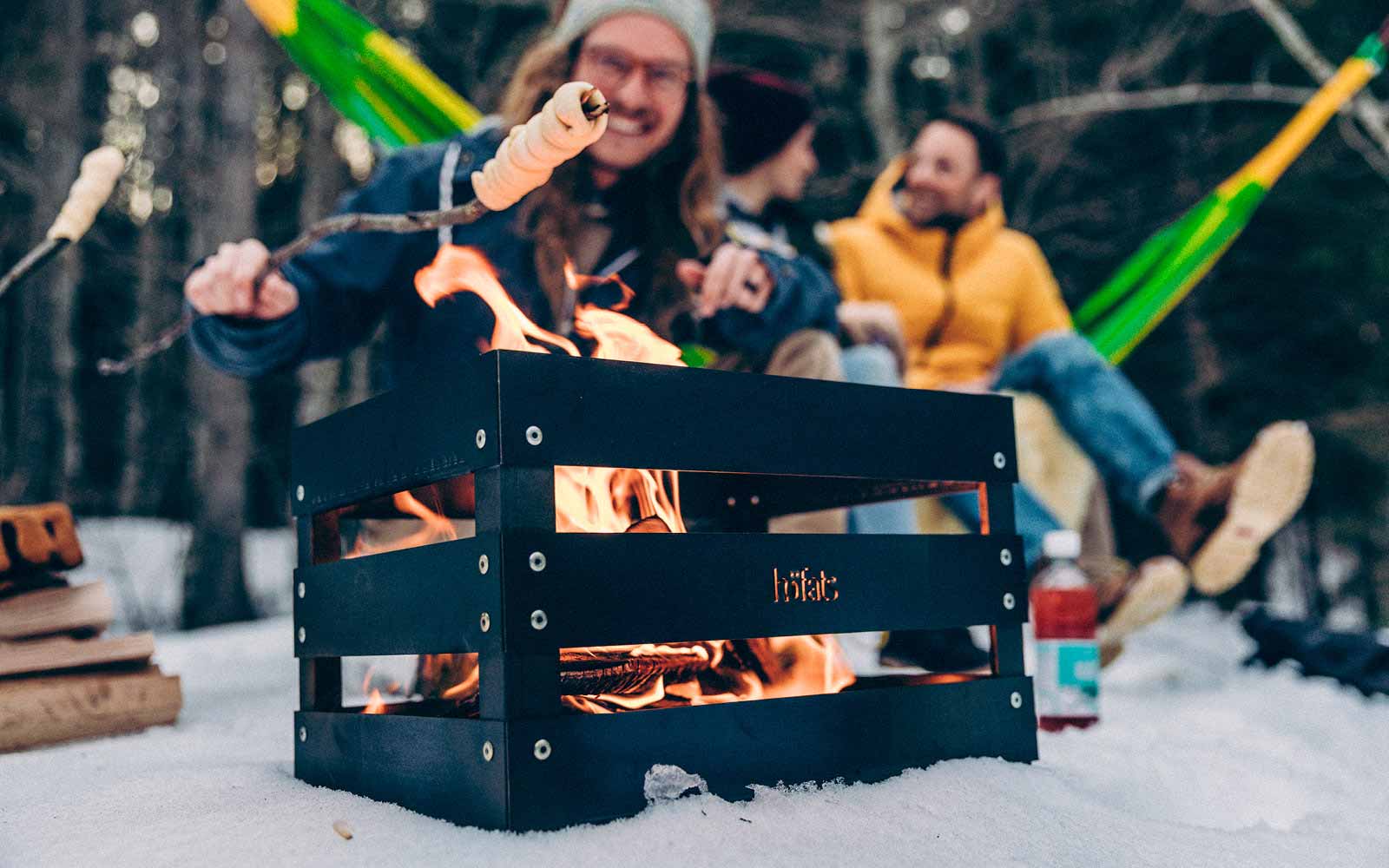 La photo présente une personne en train de cuisiner quelque chose sur un feu, avec le SPIN 120 Feu de Table en argent.