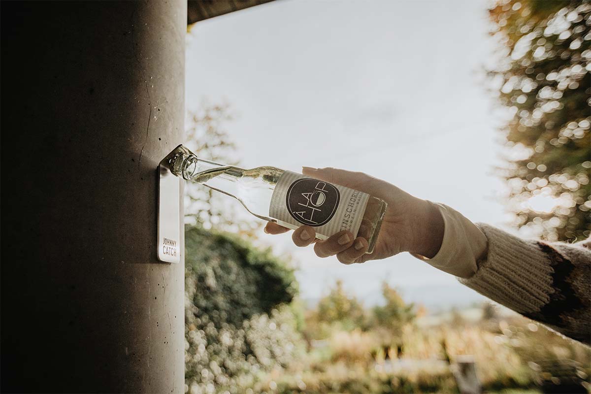JOHNNY CATCH Magnet Bottle Opener silver A person holding a bottle of water, with the Johnny Catch Magnet Bottleopener adding a functional and elegant touch to the scene.
