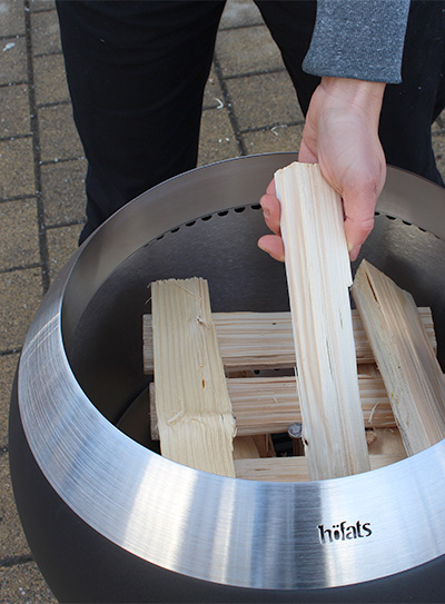 Une personne place un morceau de bois dans le MOON 45.