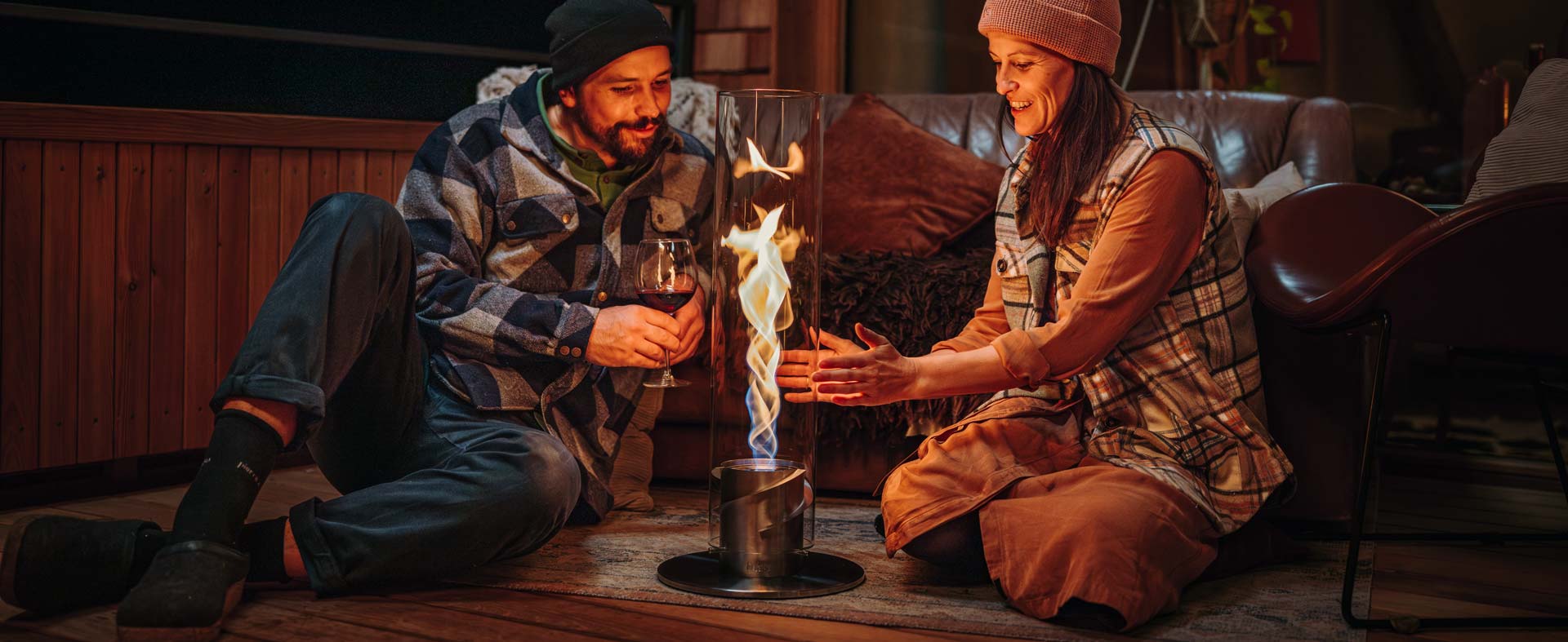 two men sitting on the floor next to a fire