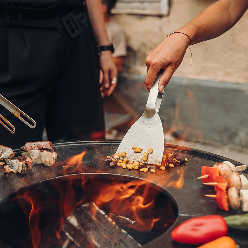 Een beeld van een persoon die eten bereidt op een grill