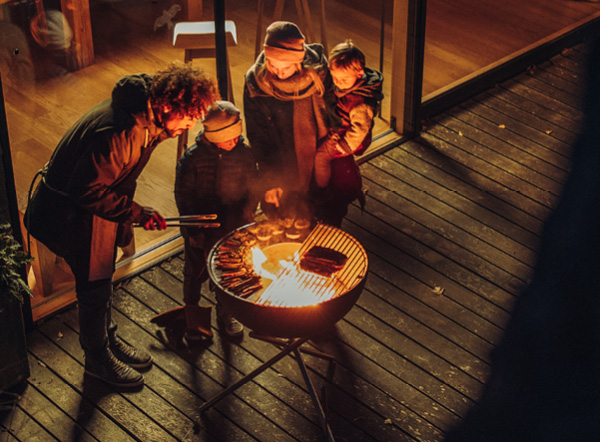 Christmas menu on the BOWL Bowl 70 with tripod is shown as three people are standing around a fire pit, creating a stylish and accessible visual.