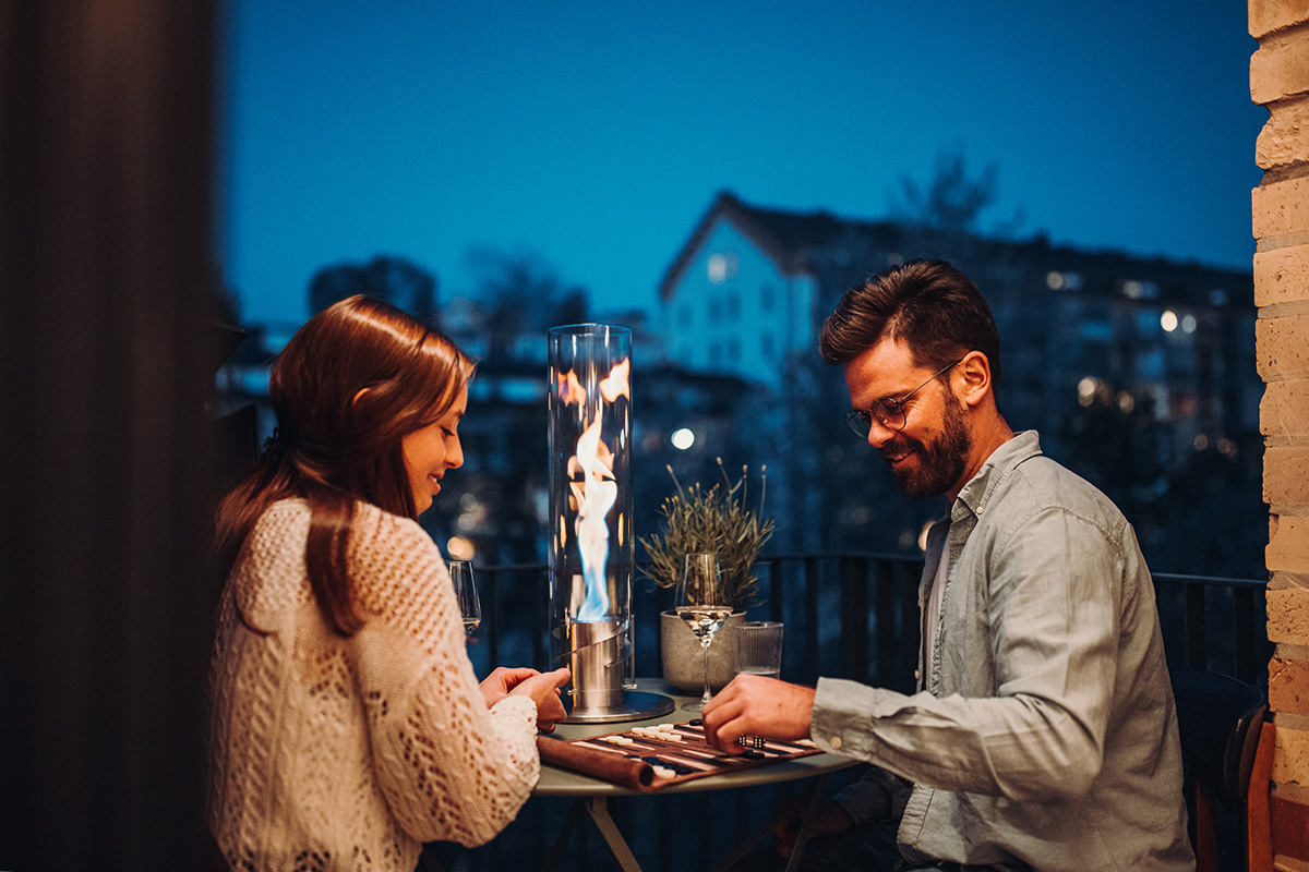 SPIN 120 Tabletop Fireplace silver The Spin 90 Tablefire silver integrates seamlessly into the setting, where a man and woman sitting at a table with a candle.