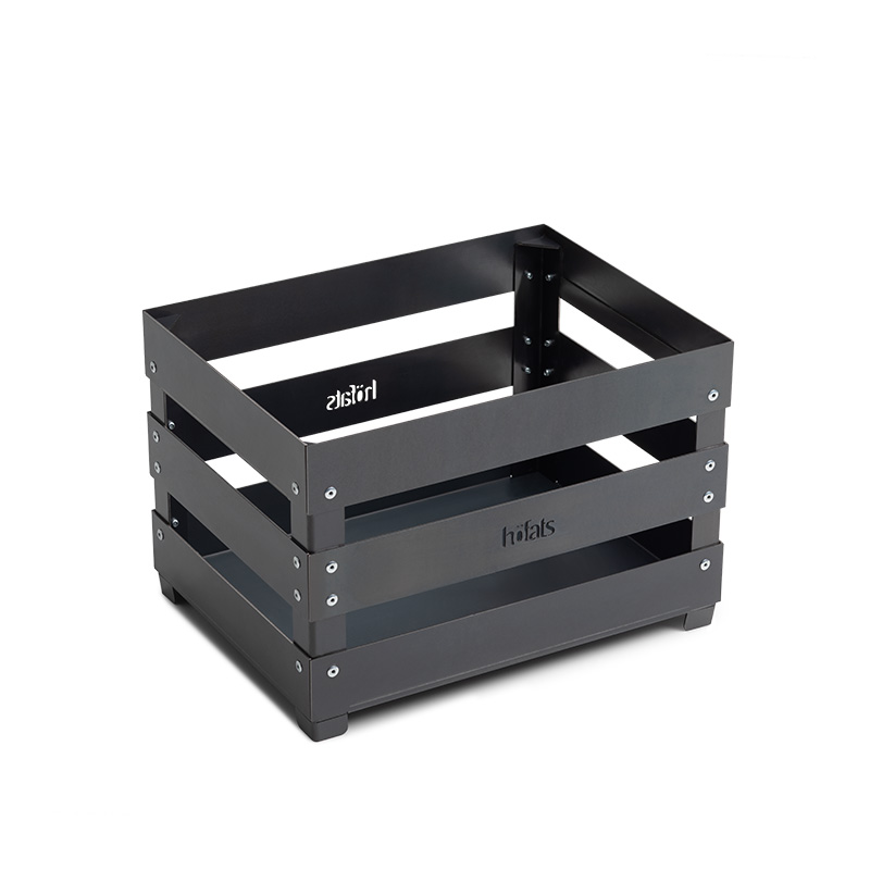 CRATE Feuerkorb Szene zeigt eine schwarze Box mit einem Logo darauf, in der der Crate Firebasket durch seine praktische Eleganz hervorsticht.