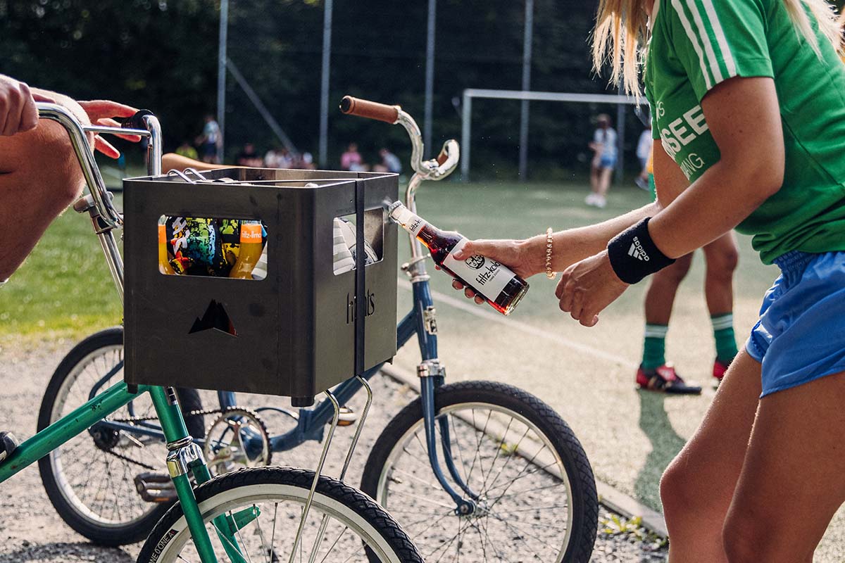 BEER BOX Fire Basket A depiction of a woman in a green shirt, featuring the Beer Box Firebasket as a central and purposeful element.