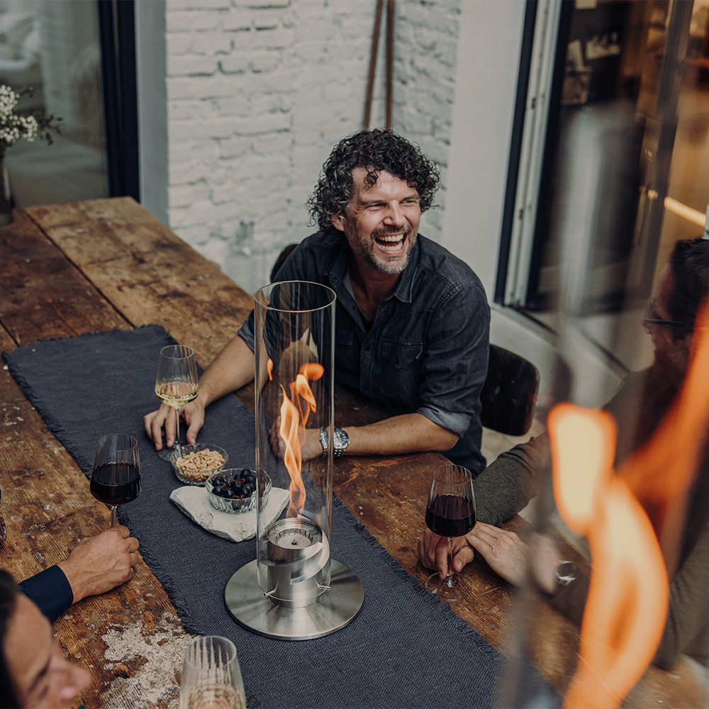 An inviting scene with a man is sitting at a table with a glass of wine, highlighted by the presence of the Hofats Spin 120 silver