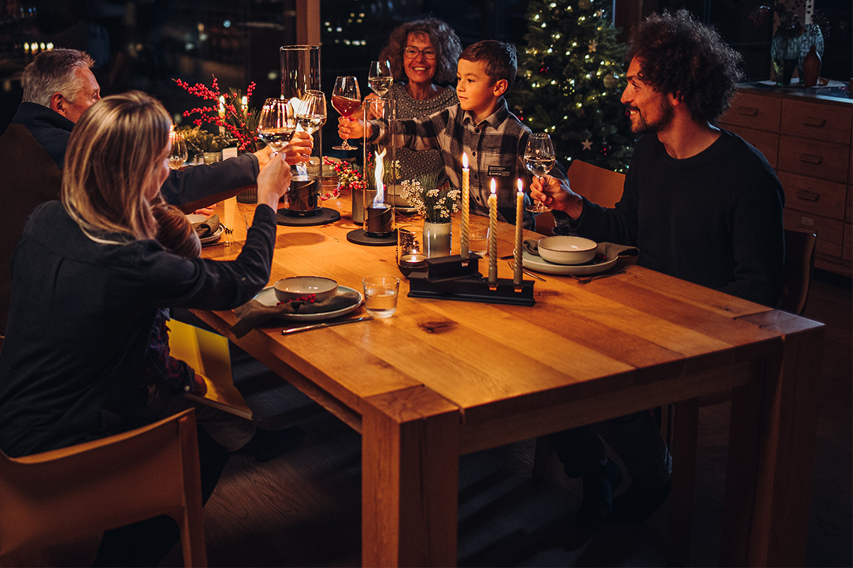 HENRY METAL I+II Kandellaar-set zwart De foto toont een groep mensen die rond een tafel zitten, met de HENRY METAL II Kaarshouder zwart.