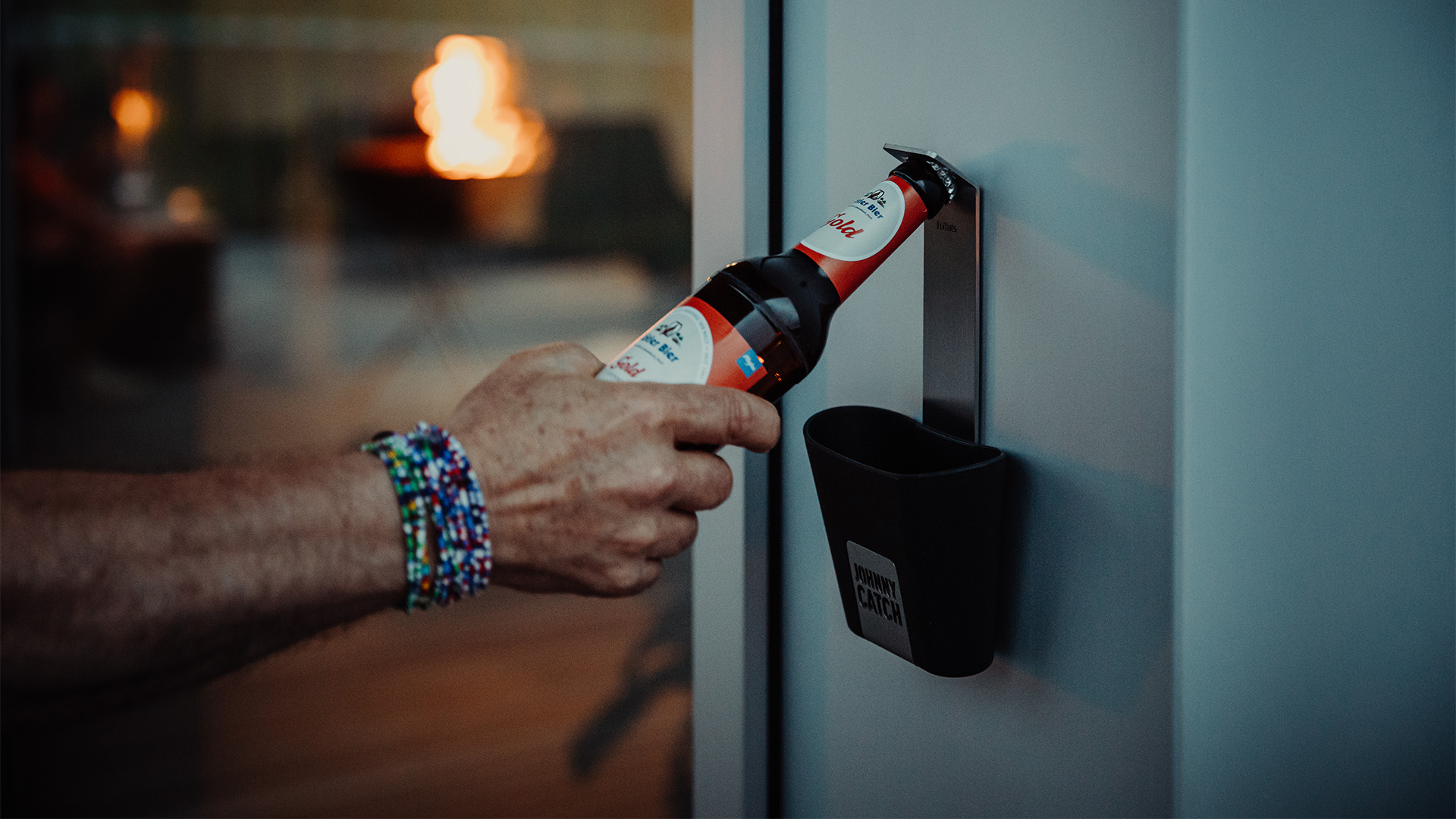 Szene, in der eine Person mit einem Flaschenöffner eine Flasche öffnet, wobei der Johnny Catch Cup durch seine praktische Eleganz hervorsticht.
