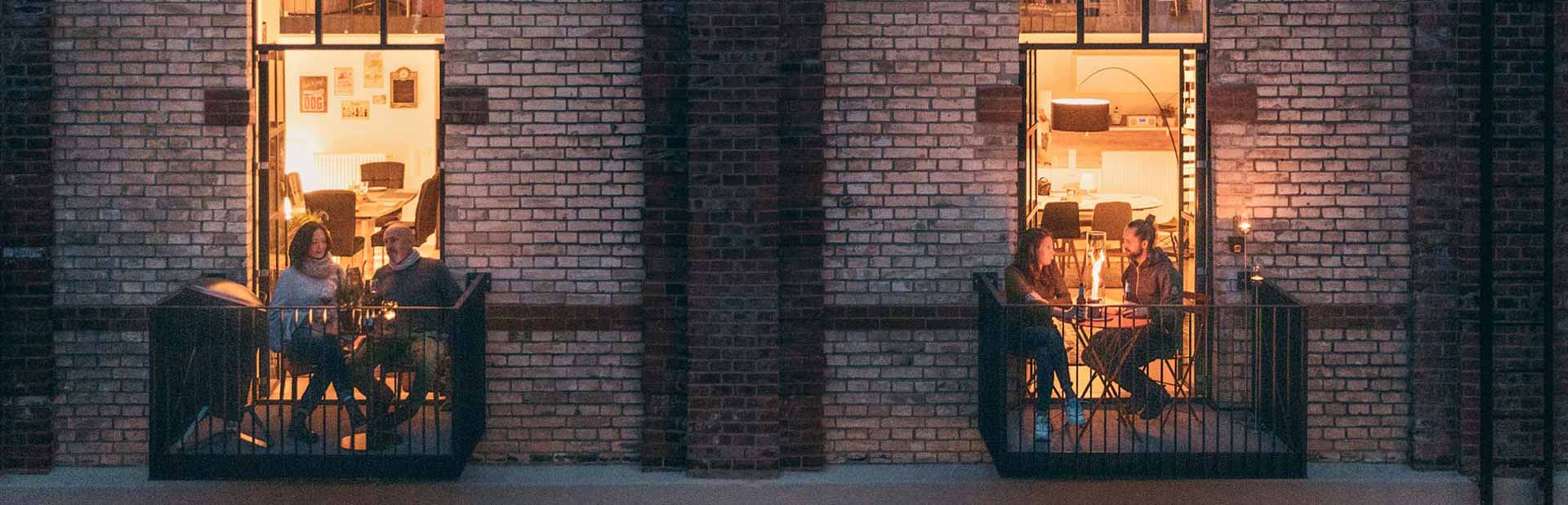 Deze afbeelding toont mensen die 's nachts op het balkon van een gebouw zitten, met de CONE.
