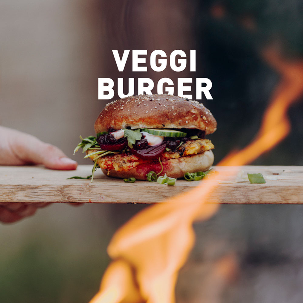 An image showing a person holding a hamburger with a fire in the background