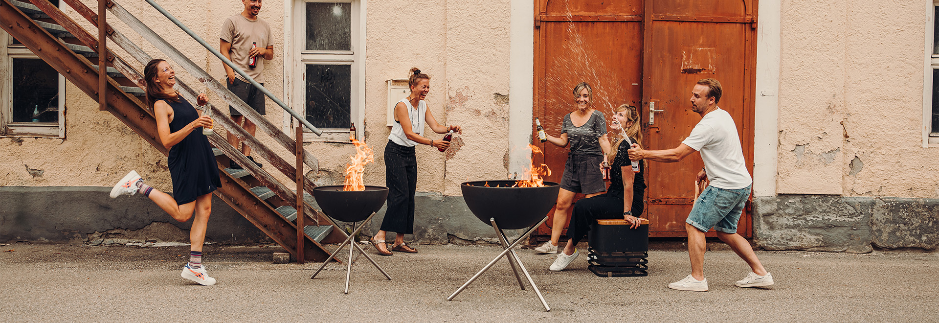 Een groep mensen staat rond een vuurplaats.
