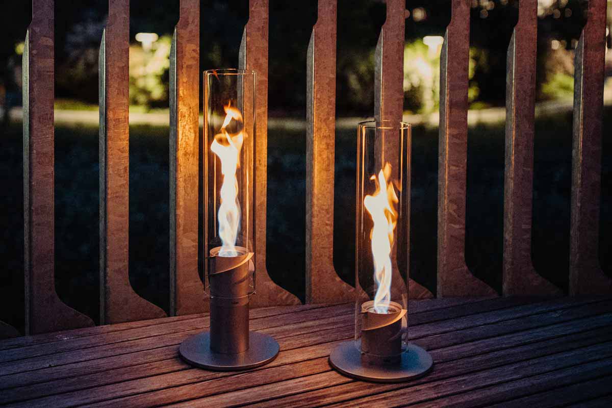 SPIN 900 Stand Elevation silver This image shows two candles on a wooden table, with the SPIN 90 Table Fire silver.