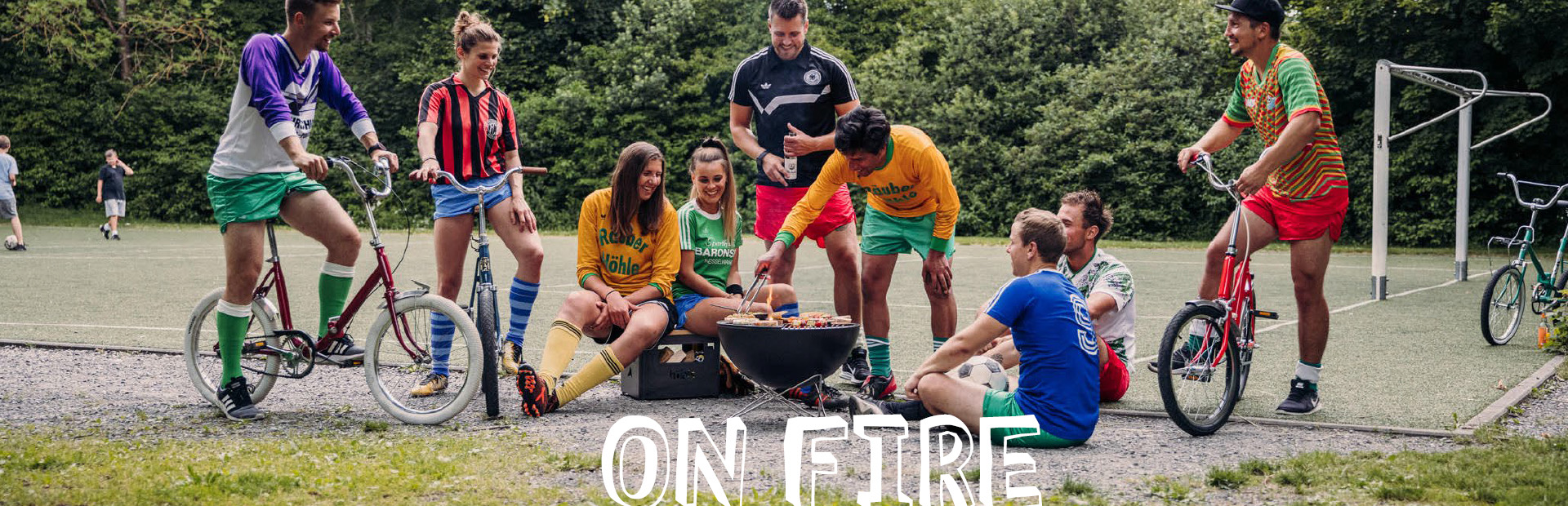 a group of people dressed in football clothing standing around a campfire. The picture shows the Bowl 57 starstand and Beerbox.