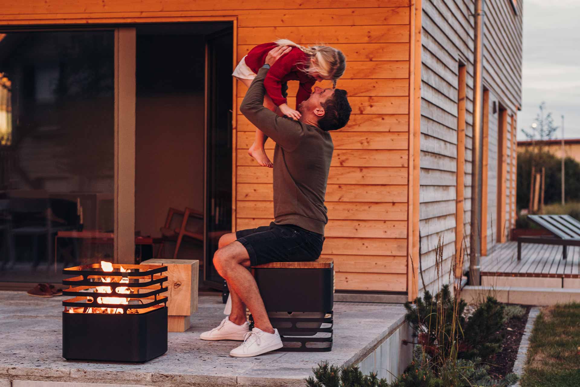 CUBE Board Depicted here is a man sitting on a fire pit, with the CUBE Board.