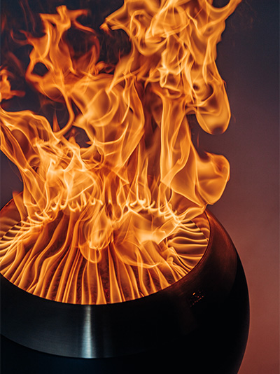 Een uitnodigende scène met een vuurplaats waar vlammen binnen branden, benadrukt door de aanwezigheid van de MOON 45.