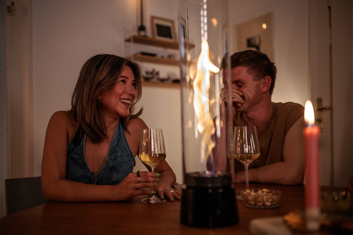 The Spin Air 1200 Tablefire Emaille adds cozy charm to the room where a woman lounges on a sofa.