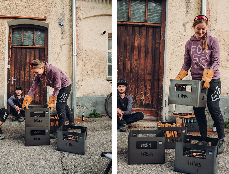Cette image montre une femme en train de déposer une boîte à pizza devant une maison, à côté du brasero BEER BOX.