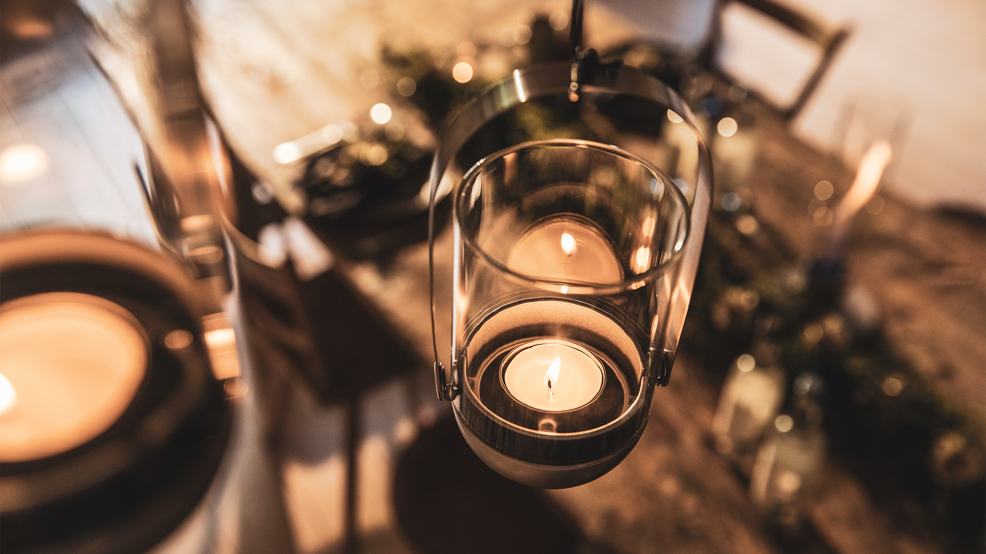 Deux bougies sont allumées sur une table, enrichies par la présence du système de suspension de bougie Gravity Candle, qui allie design et utilité.