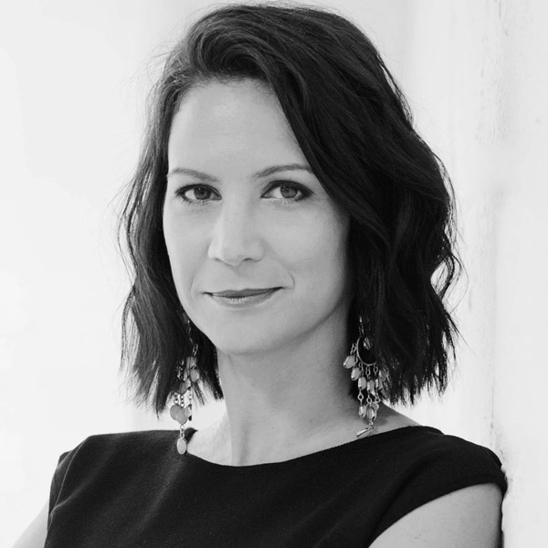 Eine Frau mit kurzen Haaren und einem schwarzen Oberteil.