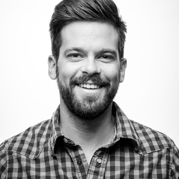 Ein Mann mit Bart lächelt in die Kamera.