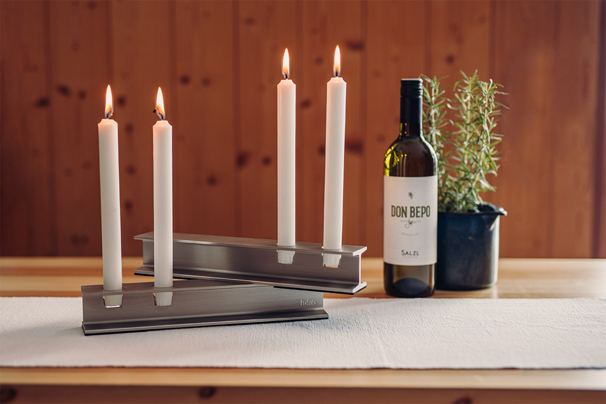 HENRY METAL II Kandelaar zilver Deze afbeelding toont een fles wijn en een kaars op een tafel, met de HENRY METAL II Kaarsenhouder in zilver.