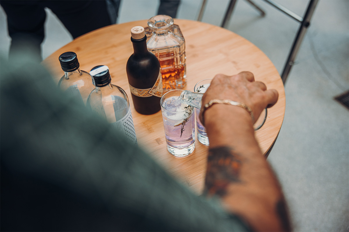 BOWL 57 Board Depicted here is a person sitting at a table with a bottle of alcohol, with the BOWL 57 Board.