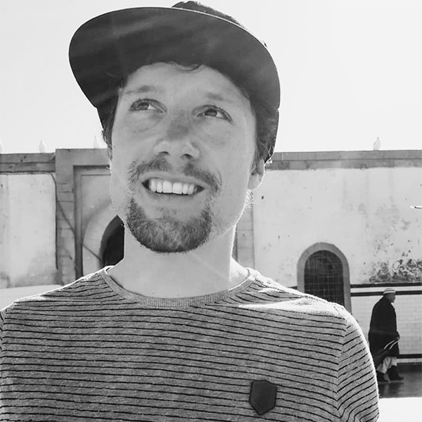 Ein Mann mit Hut und gestreiftem Shirt.