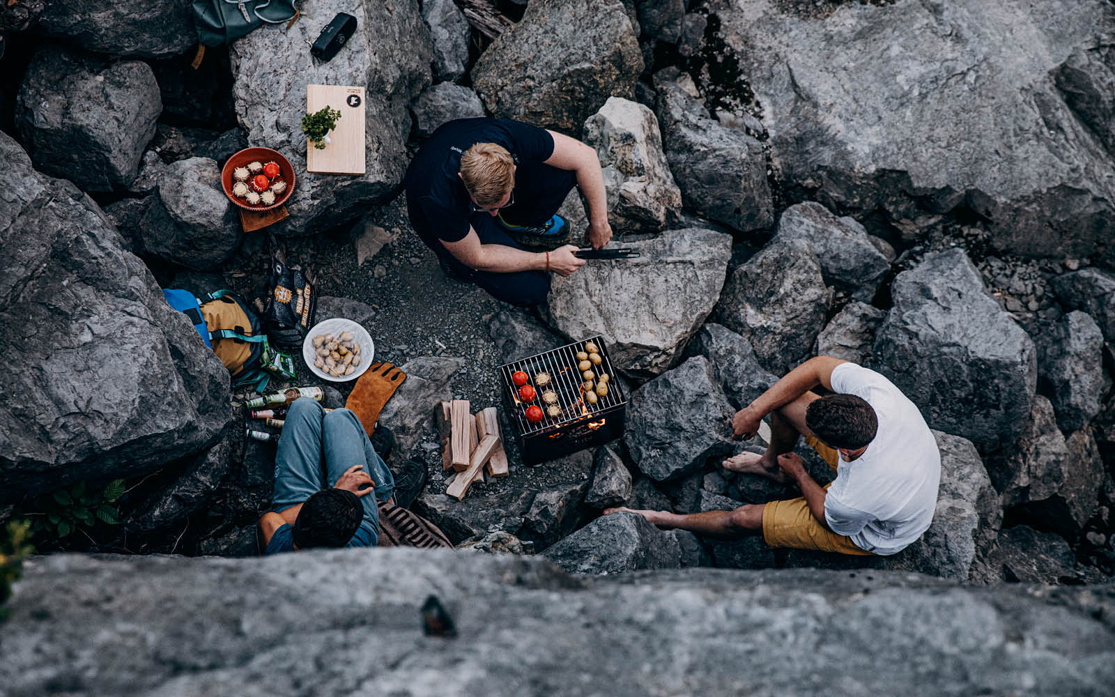 Das Foto zeigt eine Gruppe von Personen, die auf einem Felsen sitzen, mit dem BEER BOX Feuerkorb.
