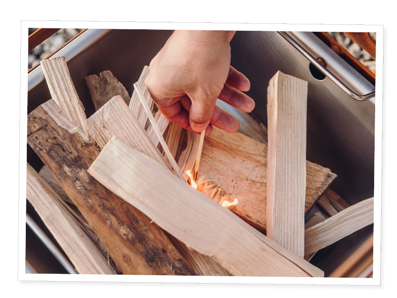 A person is putting wood into a fire
