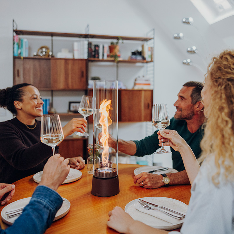 Vier Personen sitzen am Tisch mit SPIN air und stoßen mit Weingläsern an.