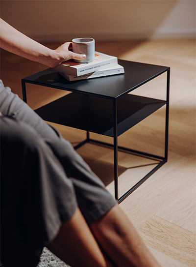 FIRE FRAME Lounge Tisch mit zwei Büchern und einer Tasse