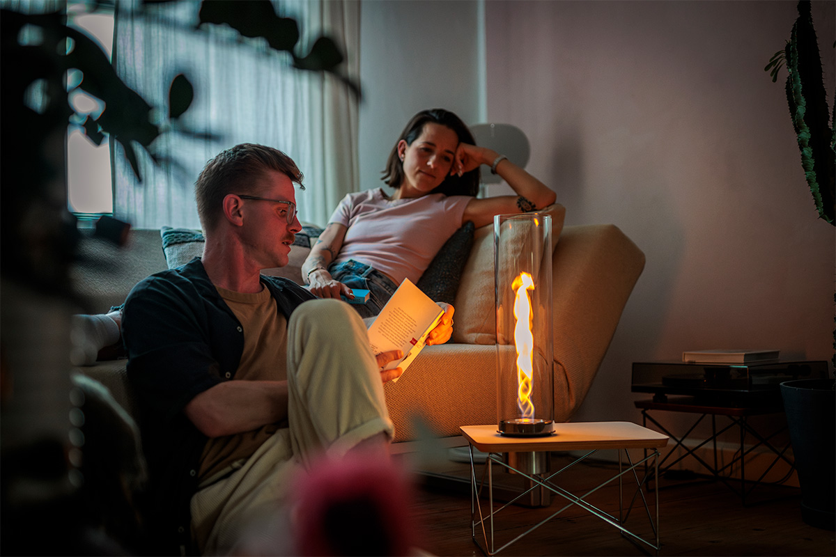 SPIN air 900 Einbau Eine Frau und ein mann sitzen in Wohnzimmer und blicken auf SPIN air 1200 Einbau im Beistelltisch vor ihnen.