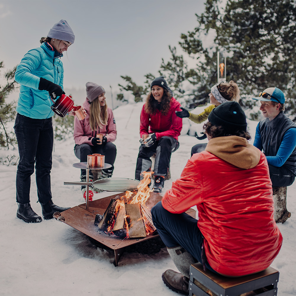 a group of people sitting around a fire showing the triple firebowl