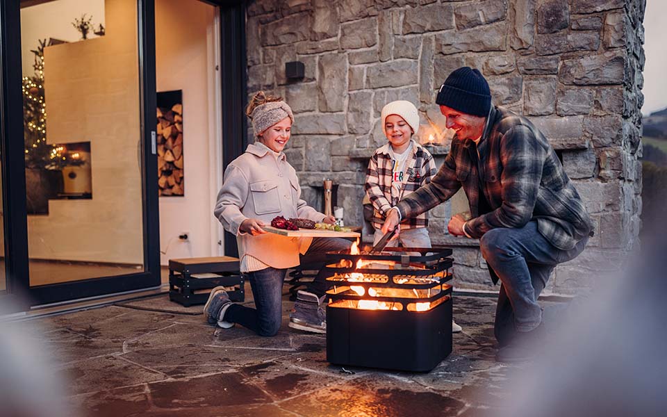 An image showing a couple roasting marsh on a fire, with the Atmospheric image Christmas for Console.