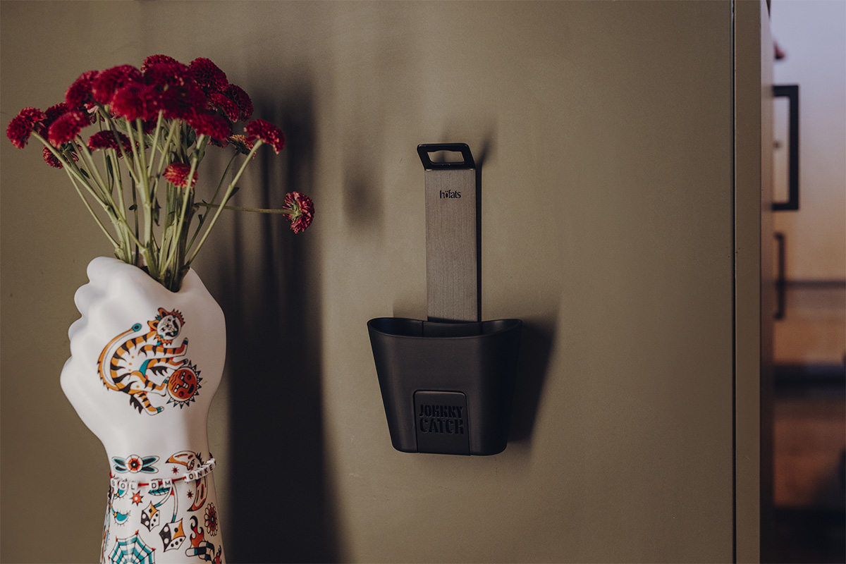 JOHNNY CATCH Cup Flaschenöffner schwarz Der 00842 Johnny Catch Cup Black Flaschenöffner fügt sich nahtlos in die Umgebung ein und zeigt eine Vase in Form einer Hand mit Blumen.