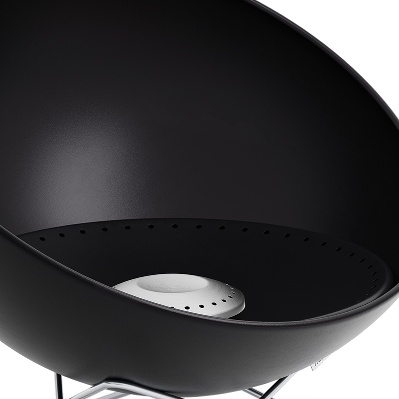 La photo présente un barbecue noir avec un couvercle, avec le cendrier BOWL 57.
