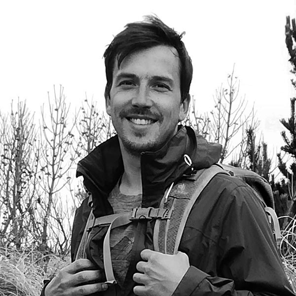 Ein Mann in einem Feld mit einem Rucksack.