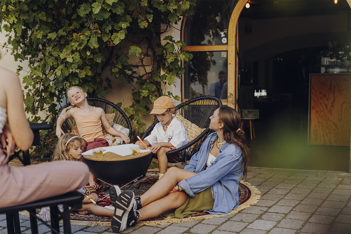 BOWL 57 Board The 00569 BOWL 57 Board integrates seamlessly into the setting, where a group of people is sitting on a patio.
