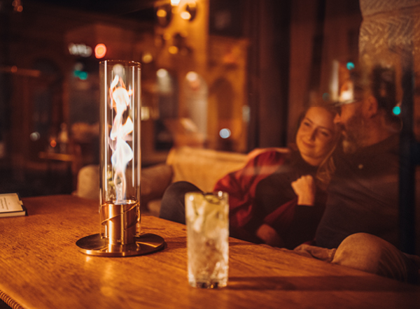 A man sitting at a table with a woman, enjoying the warmth of the SPIN Tablefire