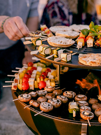 Abgebildet ist ein großer Grill mit Essen darauf, mit dem BOWL 70 Warming Ring.