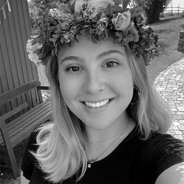 Eine Frau steht auf einer Brücke und schaut auf das Wasser.