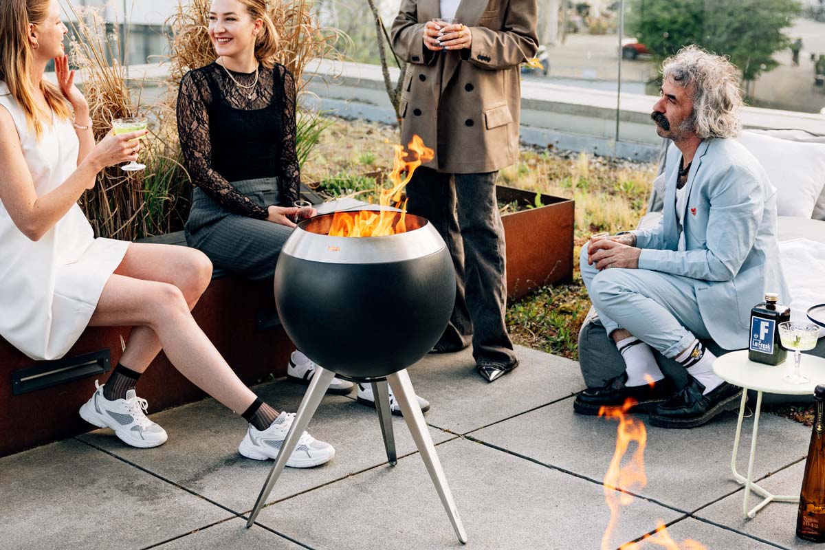 MOON 45 Fire basket with high stand A group of people sitting around a fire pit the 00717 Moon 45 with high stand complements the moment with its thoughtful design.