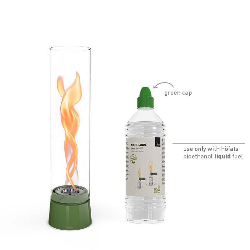 A bottle of bioethanol liquid and a fire in a SPIN Tablefire next to it the 00819 Spin Air 1200 Tablefire Emaille green complements the moment with its thoughtful design.