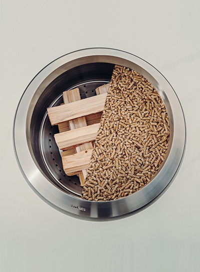 a metal bowl filled with wood sticks.