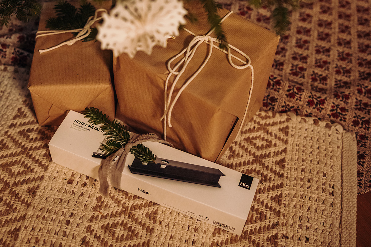 HENRY METAL II Bougeoir noir Le 00663 HENRY METAL II noir est présenté à côté de cadeaux de Noël emballés, créant une image élégante et accessible.