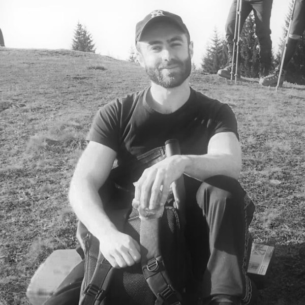 Ein Mann sitzt auf dem Boden mit gekreuzten Beinen.